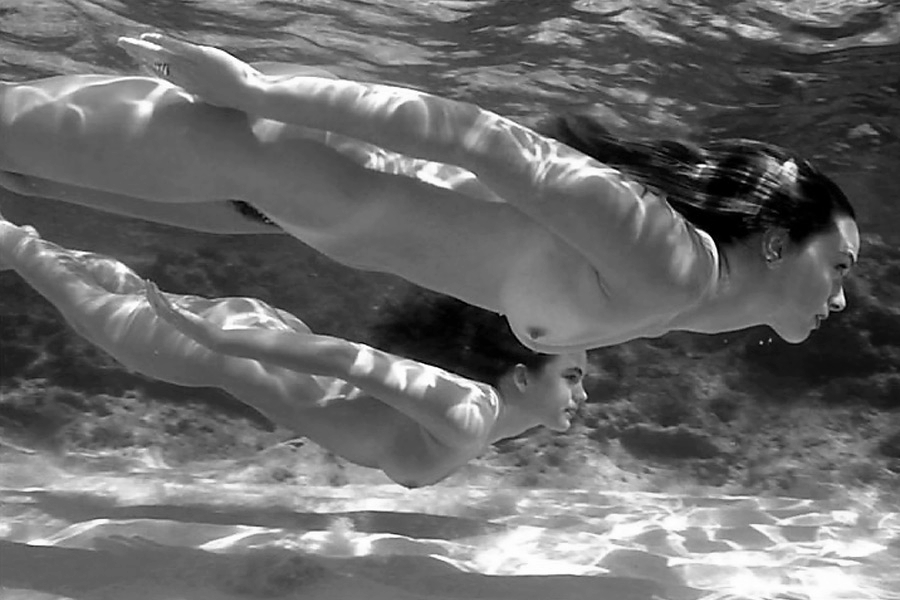 Голая женщина купается в бассейне
